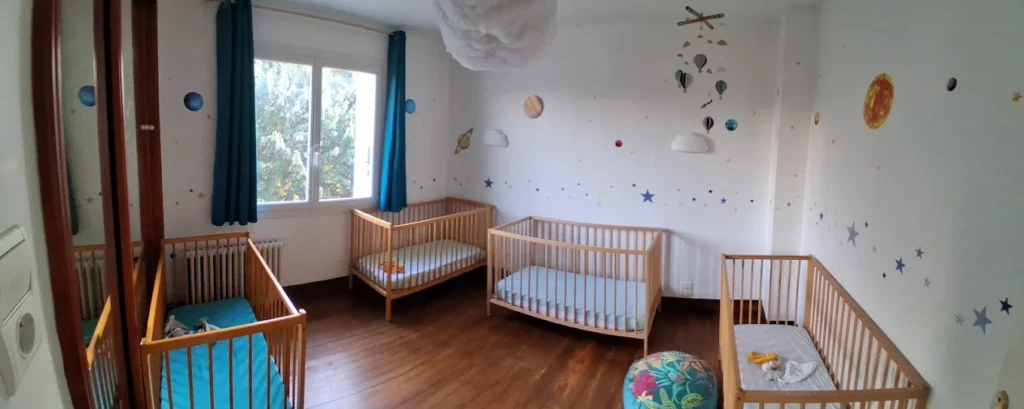 chambre-bebes-tout-petits-lits-mam-super-poppins-blagnac.jpg Chambre de repos aménagée pour les bébés et tout-petits avec quatre lits à barreaux et décoration murale sur le thème de l'espace à la Maison d'Assistantes Maternelles (MAM) Super Poppins à Blagnac